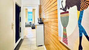 A hallway with wooden paneling, a refrigerator, and a large mural on the wall. - Modern Studio for 3 Near FAC Platz (Wien)