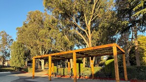 A wooden pergola structure with a sign indicating 'Canberra Park Motel.' - Canberra Park Motel (Watson)