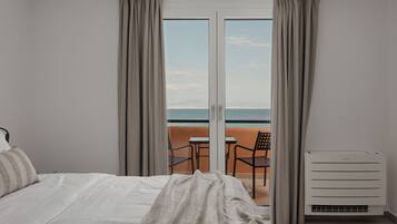 Habitación Deluxe, balcón, vistas al mar | Caja fuerte, tabla de planchar con plancha, wifi gratis