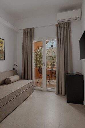 Suite familiale, balcon, vue partielle sur la mer | Aire de séjour