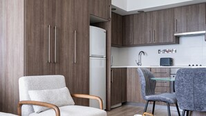 Une chambre d’hôtel moderne comprenant un coin salon, une cuisine équipée d’un grille-pain et un lit.