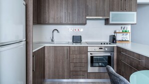 Une cuisine moderne avec des meubles en bois, des appareils en acier inoxydable et un four à micro-ondes encastré.