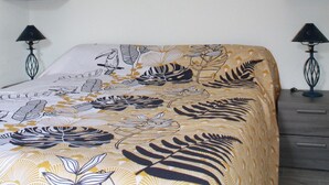 A bedroom with a bed, wall art, a hanging light, and built-in shelving. - AGATHOISE MAS at CAP D'AGDE (Agde)