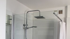 A glass-enclosed shower with a handheld showerhead, a glass door, and a shower curtain. - AGATHOISE MAS at CAP D'AGDE (Agde)