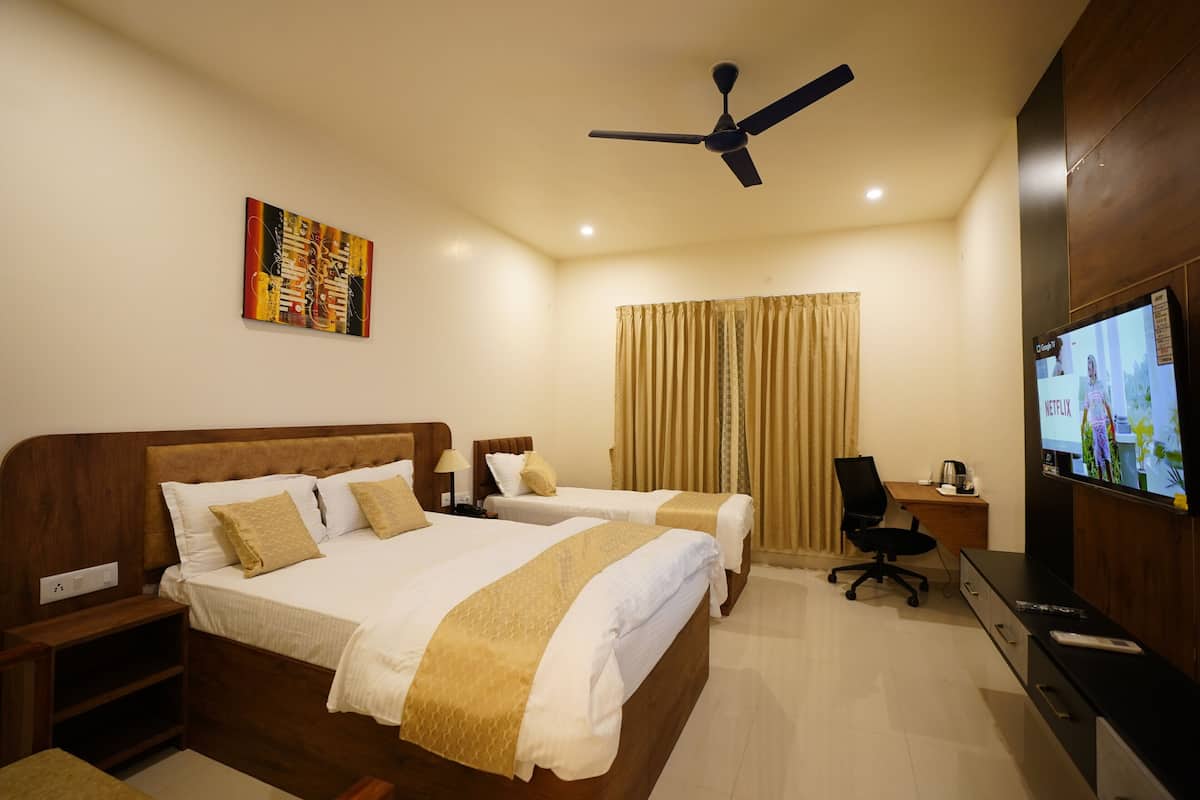 A hotel room with a bed, two bedside tables, a desk, a chair, a TV, and a ceiling fan.