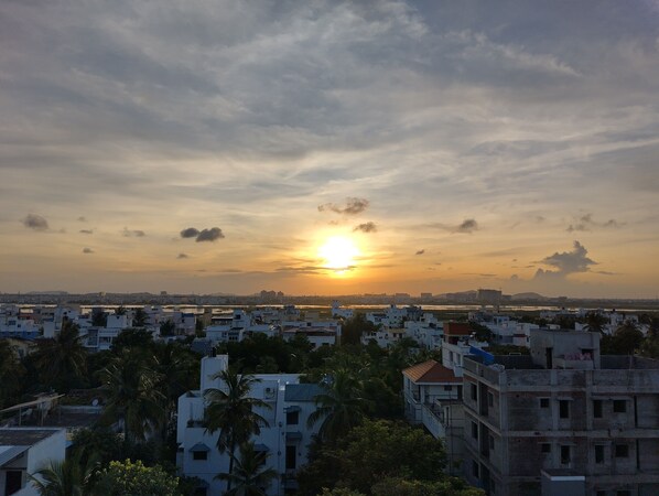 A cityscape with buildings and a sunset. - DrizzleDrop Inn Chennai (Chennai)