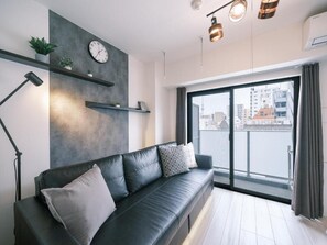 Apartamento superior, sacada, vista para a cidade | Área de estar | TV de tela plana