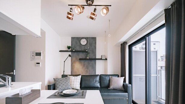 Una sala de estar moderna con comedor, un sofá, una mesa de centro y un ventanal grande.