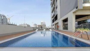Una piscina en la azotea con vistas despejadas del horizonte de la ciudad.