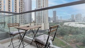 Un balcón con vistas a edificios altos y un parque.