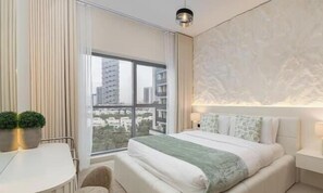 Un dormitorio moderno con un ventanal grande, una cama, una mesita y una silla.