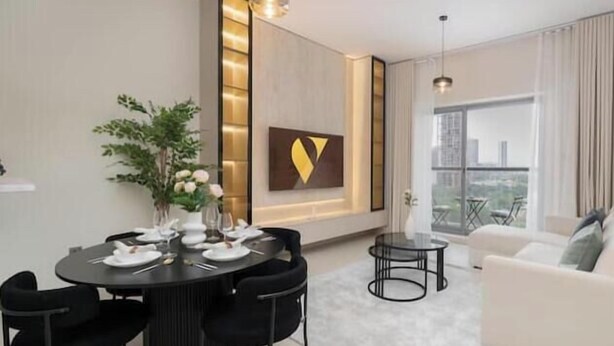 Una sala de estar moderna con comedor, un sofá blanco y un ventanal con vista a la ciudad.