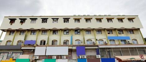 A multi-story building with a row of windows on the ground floor, likely housing shops or businesses.