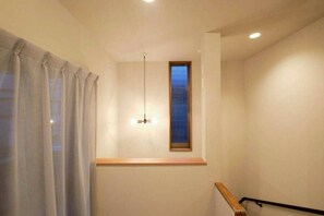 A room with a window, a ceiling fan, and a wooden ledge. - Meguro Honcho (Tokyo)