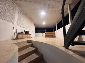 A staircase leading to a room with a wooden bench, a small table, and a wall with a textured pattern. - D 6 apartment at the Pier 5 of 6 (Ko Pha-ngan)
