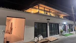 A building with a large open doorway, a balcony, and a storefront with glass doors. - D 6 Apartment 6 of 6 (Ko Pha-ngan)