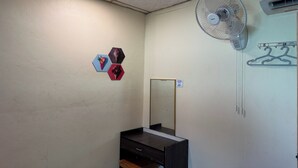 Una habitación con ventilador de techo, espejo y aire acondicionado mural.