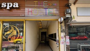 Un hostal con recepción, señalización de spa y exhibición de zapatos en el exterior.