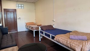 Una habitación con dos camas, un sofá y una puerta.