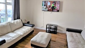 Una sala de estar con un sofá, un reposapiés y una mesita.