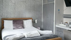 A bedroom with a bed, bedside table, lamp, wardrobe, desk, chair, and a television mounted on the wall. - Charming BnB Retreat in East Riding of Yorkshire (East Riding of Yorkshire)