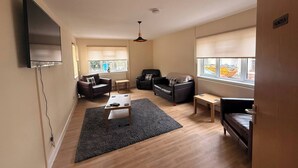 A living room with a flat-screen TV, two sofas, a coffee table, and a small table. - Spacious House Sleeps 10 -Near BikePark Wales -Central -Parking (Troedyrhiw)