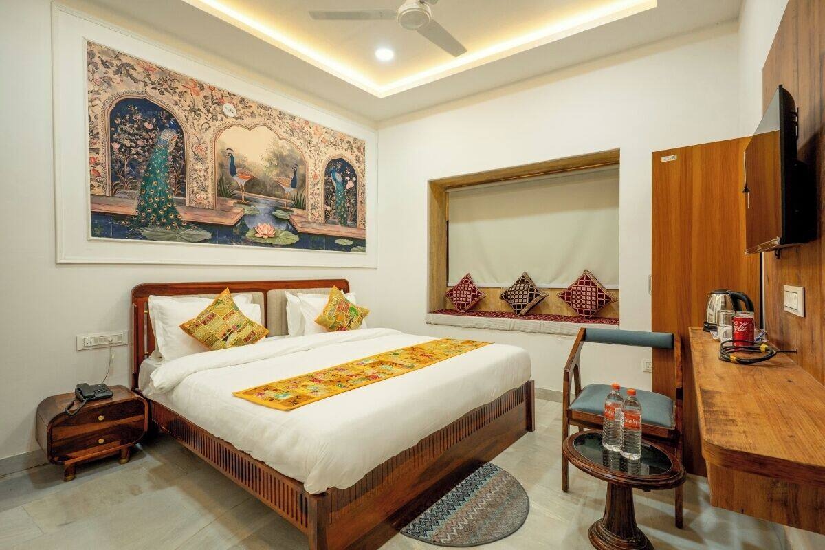A bedroom with a bed, bedside table, chair, and a TV.