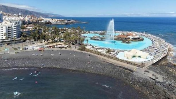 A coastal resort with a central fountain, a pool, and a rocky beach area. - Vv03. Atardecer Martianez (Puerto de la Cruz)