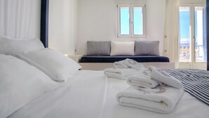 Un dormitorio con cama, almohadas, una ventana y vistas al exterior.