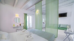 A hotel room with a bed, a desk, a chair, a TV, a bathroom, and a window. - Villa Ianira with Private Terrace, Wi-Fi and Air Conditioning (Koufonisi)