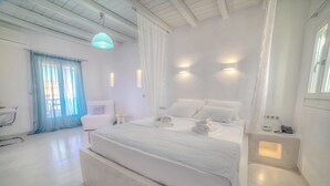 Ein modernes Schlafzimmer mit einem großen Bett, Nachttischen, einem Sessel und einem kleinen Tisch.