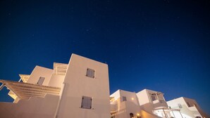 A white building with stone walls, a balcony, and a night sky with stars. - Villa "Pasithoe" with Private Terrace, Wi-Fi and Air Conditioning (Koufonisi)