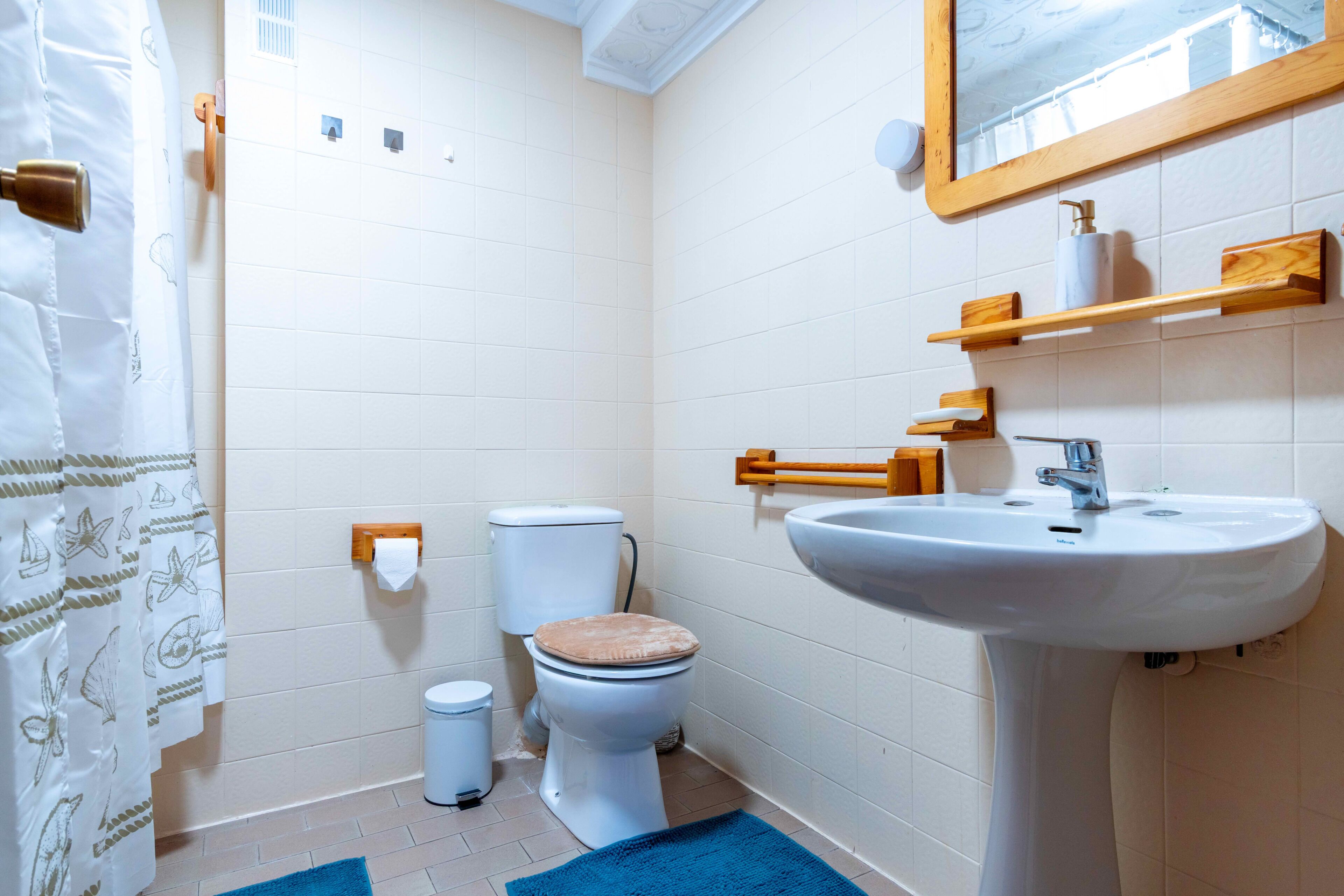 A bathroom with a toilet, sink, and shower curtain.
