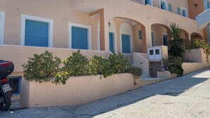 A building with multiple balconies, blue doors, and a parked motorcycle. - Cozy  twin beds studio Kalymnos (Kalimnos)