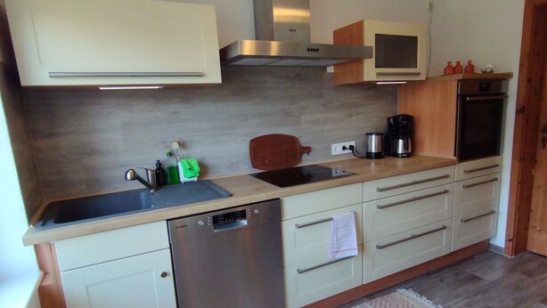 Una cocina moderna con lavavajillas Bosch, microondas y cafetera.