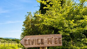 Un cartel de madera con la inscripción 'ENVIRO N'BE' en un entorno rural.