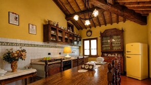 Una cocina con armarios de madera, un refrigerador amarillo y una mesa de comedor de madera.