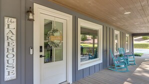 A porch with a white door, a welcome sign, a lantern, and two rocking chairs. - Boat Dock + Yard: Lake Lanier Gem in Gainesville (Gainesville)