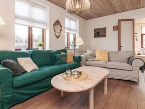 A cozy living room with a green sofa, a beige sofa, and a wooden coffee table. - 8 Person Holiday Home in Rudkobing (Rudkobing)