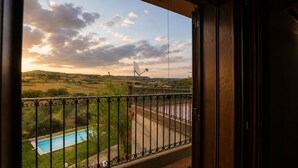 Un balcon avec vue sur une piscine et la campagne environnante.