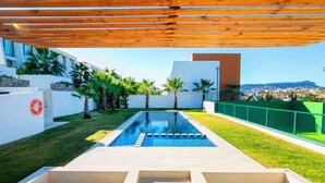 Zona de piscina exterior moderna amb una vista despejada del paisatge urbà al fons.