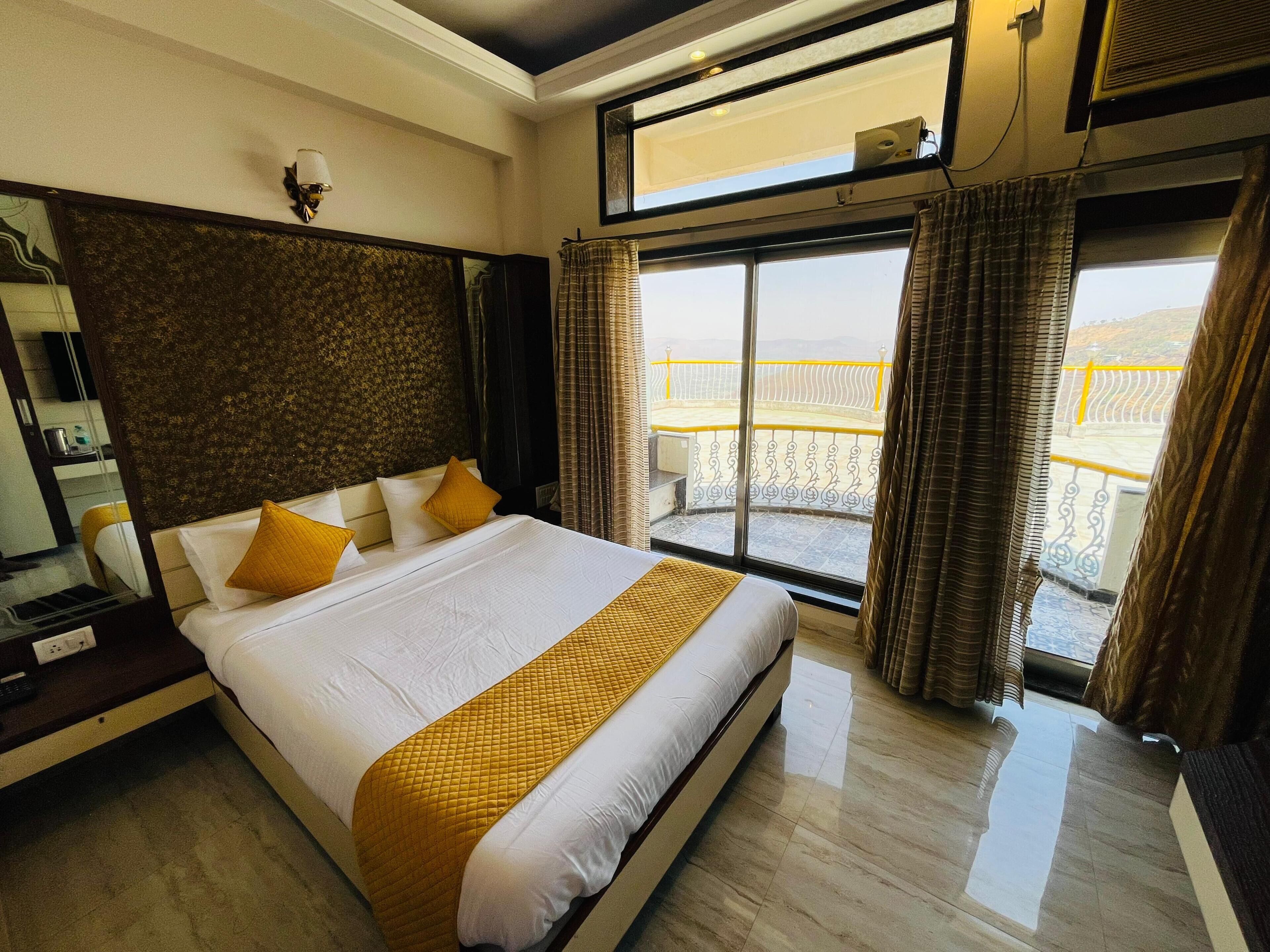 Quarto de hotel com uma cama grande, varanda e vista, e design moderno.