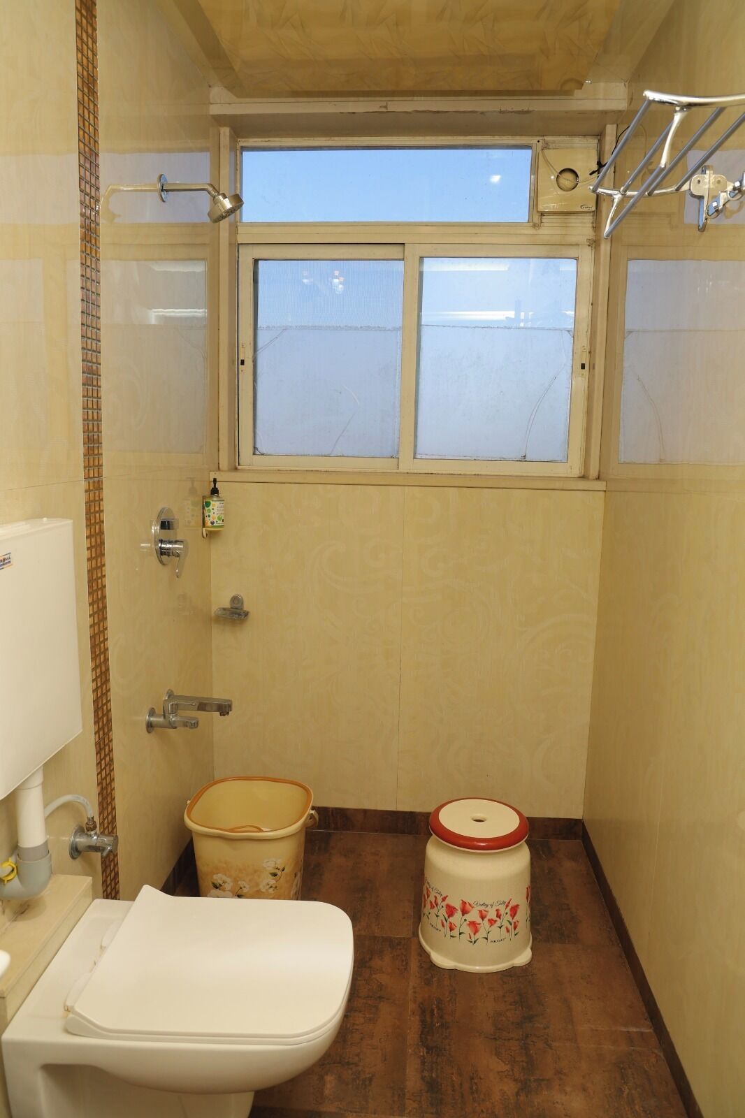 Ein kleines Badezimmer mit Toilette, Bidet und einem Fenster über dem Waschbecken.