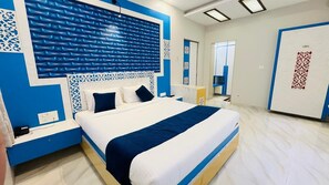 Une chambre d’hôtel moderne avec un grand lit, une table de chevet, un miroir et une armoire.