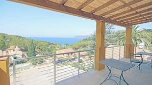 A balcony with a view of the sea, a pergola, and a table and chair. - Villa Artemis apartment 1 (Capoliveri isola d'Elba)