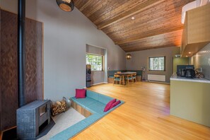 A modern interior with a fireplace, seating area, kitchen, and dining space.
