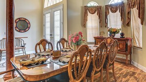 A dining room with a large wooden table, chairs, and a chandelier. - Pool & Lanai! Sophisticated Spring Hill Stay (Spring Hill)
