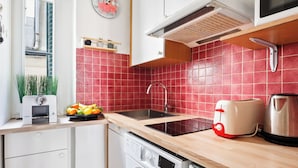 A kitchen with a sink, a toaster, a kettle, and a washing machine. - 1BR Saint-Germain-des-Prés Seine Escape (Paris)
