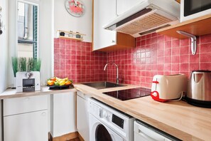 Een keuken met een spoelbak, een broodrooster, een waterkoker en een wasmachine.