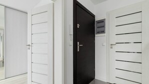Drei Türen mit unterschiedlichen Designs, eine weiße Wand und ein heller Boden.